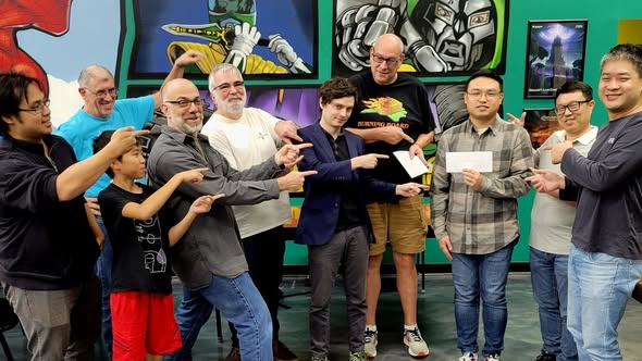 Twelve Go players lined up for the prize ceremony of the Fall 2023 Houston Go Tournament, in front of a comic book mural. Bowei Xu is third from the right.